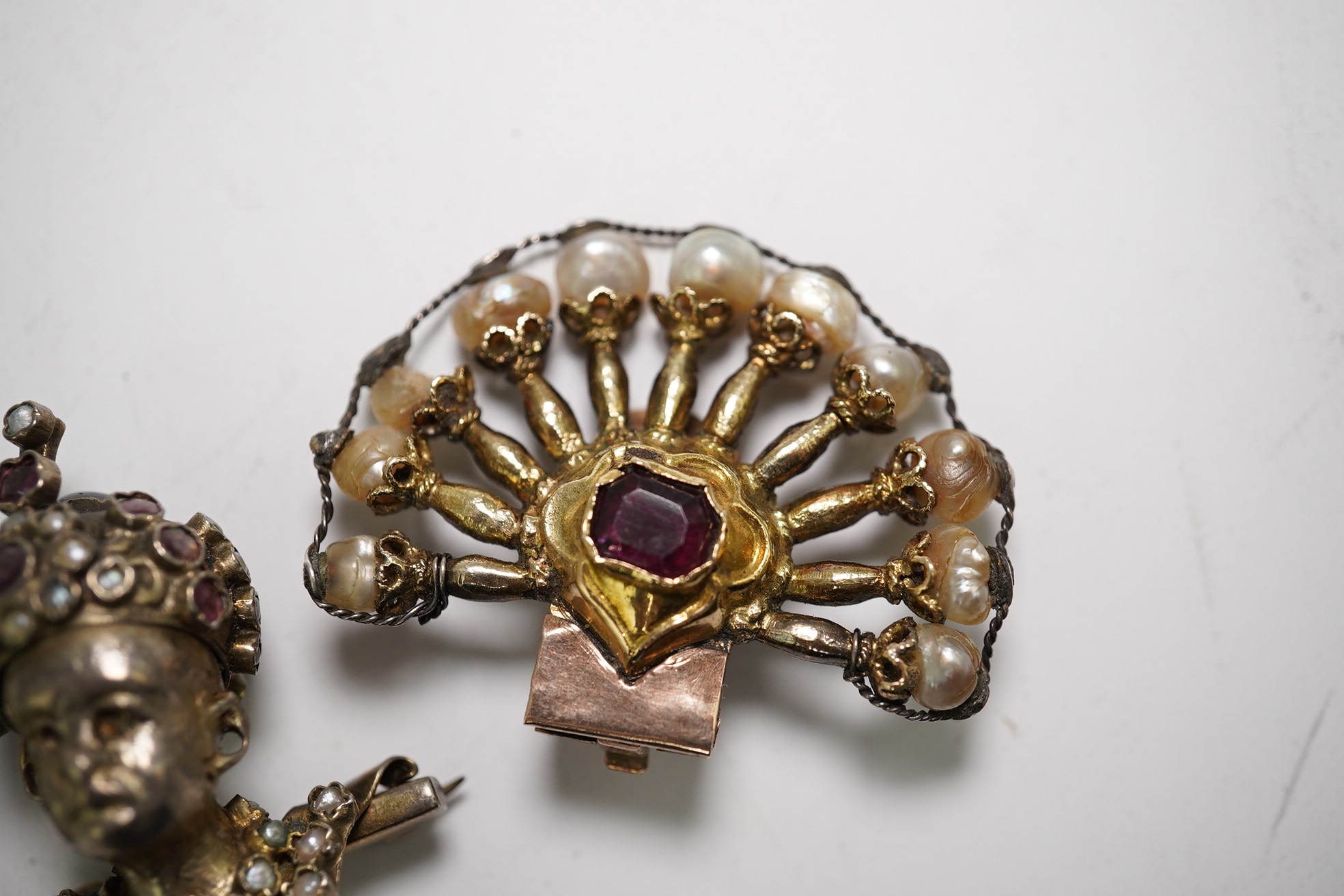 A pair of Indian ruby and baroque pearl set fan shaped ear clips, 42mm and a garnet and seed pearl set turbaned head brooch